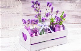 Hermosas flores de lavanda púrpura, botellas, caja de madera.